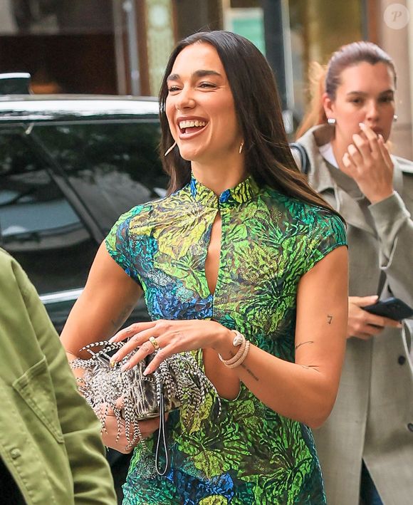 Le pop-up store se situe dans la boutique de son partenaire, au 84 Galerie de Beaujolais, du 27 mai au 7 juin 2026.

Dua Lipa a fait une apparition toute en jambes lors de son arrivée au lancement d'un pop-up à Selfridges à Londres. La chanteuse portait une robe papillon verte et bleue de Kim Shui avec une découpe sur le devant et une fente haute, associée à des bottes en autruche vertes Christian Dior FW00. Elle a complété son look avec un sac fourre-tout Kurt Geiger London en cristal macramé argenté.

© Backgrid UK/ Bestimage