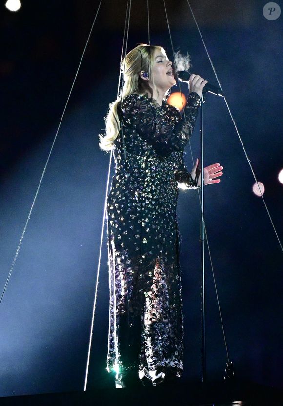 La chanteuse Louane (Louane Emera), représentante de la France au concours de l'Eurovision, interprète pour la première fois son titre Maman, en hommage à sa mère décédée lorsqu'elle avait 17 ans, devant les 80 000 spectateurs, suspendue sur une plateforme, plusieurs mètres au-dessus de la pelouse et des musiciens, du Stade de France à la mi-temps du match du Tournoi des Six Nations opposant la France à l'Écosse, à Saint-Denis, Seine Saint-Denis, France, le 15 mars 2025. © CHristian Liewig/Bestimage