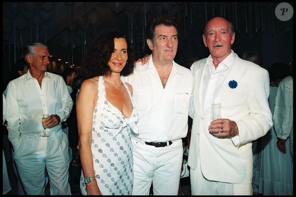 Archives - Eddy Mitchell, sa femme et Eddie Barclay lors d'une "soirée blanche" dans la villa d'Eddie Barclay "Maison du Cap" à Saint-Tropez en 1995 
ANGELI-GARCIA / BESTIMAGE