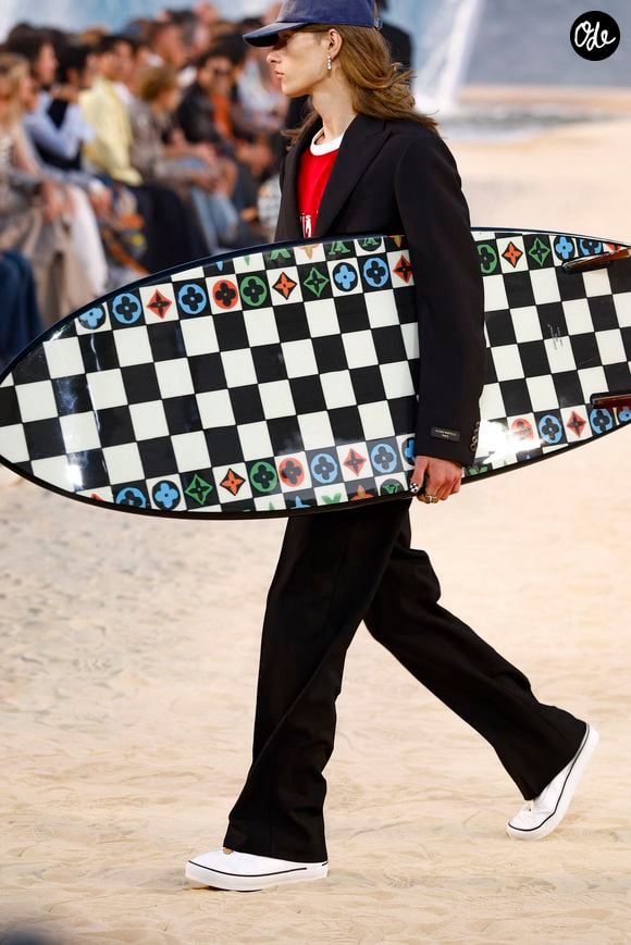 Et pour aller sur le terrain du surf jusqu'au bout, plusieurs silhouettes ont présenté une longue chevelure balayée par le vent, casquette vissée sur la tête, vêtues de combinaisons de néoprène de luxe ou paradant tout simplement... avec leur planche de surf sous le bras. 

Défilé de mode Louis Vuitton Prêt à Porter Collection Homme Printemps/Été 2027 lors de la Fashion Week de Paris, à la Cité Internationale Universitaire de Paris, France, le 23 juin 2026. © Bestimage
