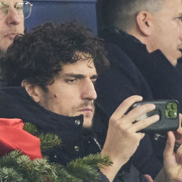 Louis Garrel dans les tribunes du match de Ligue 1 McDonald's opposant le Paris Saint-Germain (PSG) à Lyon (3-1) au Parc des Princes à Paris le 15 décembre 2024.