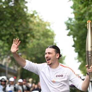 EDITORIAL USE ONLY - Le chanteur Pierre Garnier, porteur de la flamme olympique, près de l'Olympie pendant le relais de la flamme olympique à Paris, France, le 14 juillet 2024.  Photo par Paris 2024/Cedric Bufkens/SIPA PRESS/ABACAPRESS.COM
