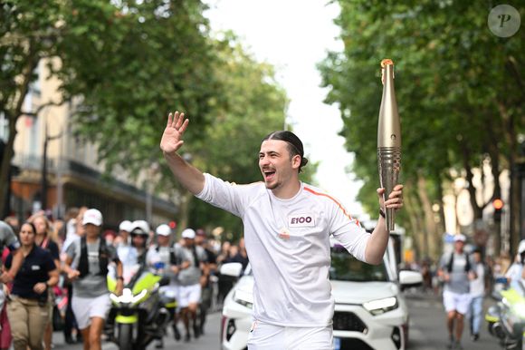 EDITORIAL USE ONLY - Le chanteur Pierre Garnier, porteur de la flamme olympique, près de l'Olympie pendant le relais de la flamme olympique à Paris, France, le 14 juillet 2024.  Photo par Paris 2024/Cedric Bufkens/SIPA PRESS/ABACAPRESS.COM