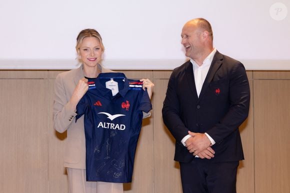 La princesse Charlène de Monaco se voit offrir un maillot dédicacé par les joueurs du XV de France de rugby, vainqueurs du tournoi des 6 nations 2025, des mains de William Servat, l'entraîneur du XV de France - La princesse C.de Monaco, en compagnie de son frère G.Wittstock, participe à la remise des prix de la "Journée du respect" au collège Charles III à Monaco, le 29 avril 2025. © Olivier Huitel / Pool Monaco / Bestimage