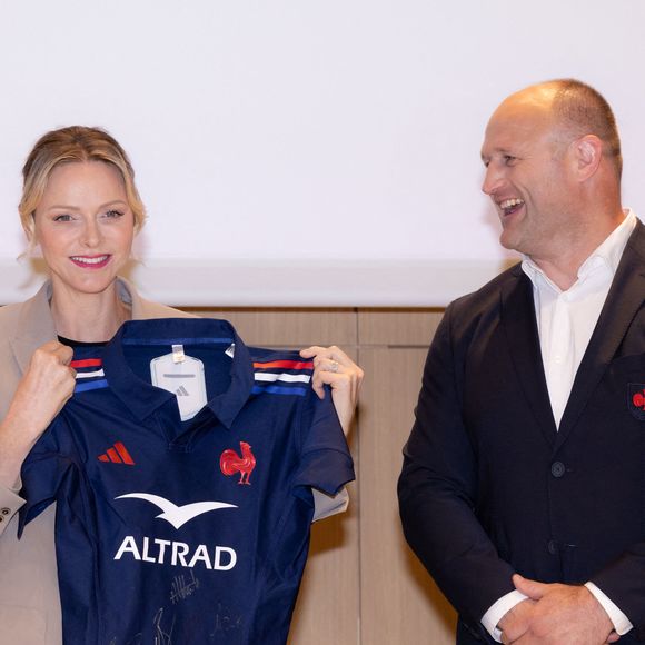 La princesse Charlène de Monaco se voit offrir un maillot dédicacé par les joueurs du XV de France de rugby, vainqueurs du tournoi des 6 nations 2025, des mains de William Servat, l'entraîneur du XV de France - La princesse C.de Monaco, en compagnie de son frère G.Wittstock, participe à la remise des prix de la "Journée du respect" au collège Charles III à Monaco, le 29 avril 2025. © Olivier Huitel / Pool Monaco / Bestimage