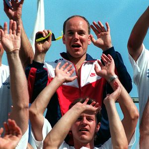 Albert de Monaco au championnat de pousse bobsleigh dans les tribunes, souriant, salut, lève les bras. AGENCE / BESTIMAGE