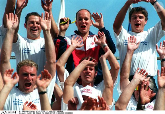 Albert de Monaco au championnat de pousse bobsleigh dans les tribunes, souriant, salut, lève les bras. AGENCE / BESTIMAGE