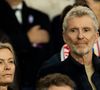 Mais c'est à quelques kilomètres de Paris qu'il vit avec sa famille.

Denis Brogniart et sa femme Hortense - Célébrités dans les tribunes du match de qualification de la Coupe du monde 2026 entre la France contre l'Ukraine (4-0) au Parc des Princes à Paris le 13 novembre 2025. © Cyril Moreau/Bestimage