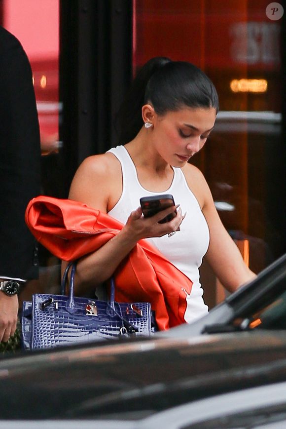 Fidèle à son style casual chic, la jeune femme portait un jean EB (environ 250 euros), un débardeur blanc Guizio (environ 32 euros) 

Exclusif - Kylie Jenner est élégante et prête pour le match des Knicks avec une veste en cuir orange. Mai 2026 New York Backgrid USA / Bestimage