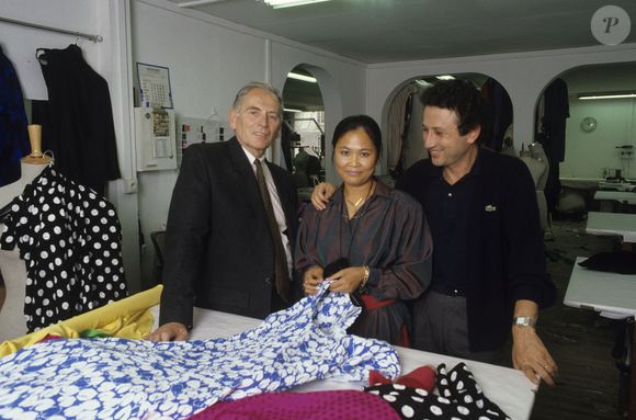 Archives - En France, à Paris, Pierre Cardin, Michel Drucker, et sa fille adoptive cambodgienne Yleng  dans l'atelier de couture de chez CARDIN où elle est première main. Septembre 1987
© Michel Ristroph via Bestimage