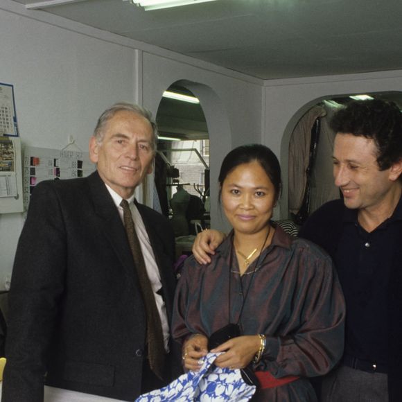 Archives - En France, à Paris, Pierre Cardin, Michel Drucker, et sa fille adoptive cambodgienne Yleng  dans l'atelier de couture de chez CARDIN où elle est première main. Septembre 1987
© Michel Ristroph via Bestimage