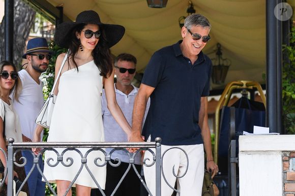 George Clooney et sa femme Amal Clooney sortent de leur hôtel, et prennent un bateau taxi pour se rendre dans un héliport pour s'envoler en hélicoptère de Venise, Italie, le 27 juin 2019.
