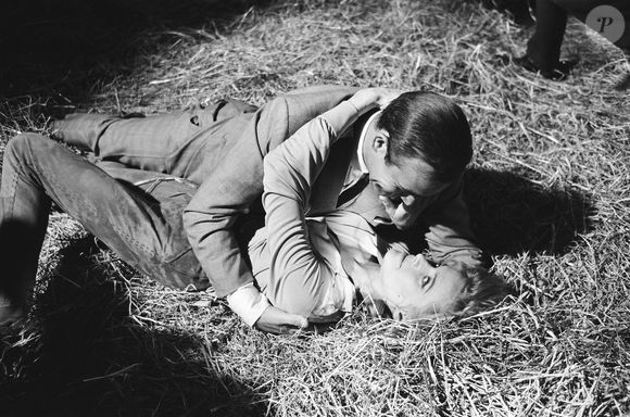 Honor Blackman – Honor Blackman dans le rôle de Pussy Galore et Sean Connery en James Bond, ici en train de filmer une scène de combat qui se transforme en scène d’amour dans la grange de Goldfinger, sur le décor extérieur des studios Pinewood. 2 juin 1964. Mirrorpix / Bestimage