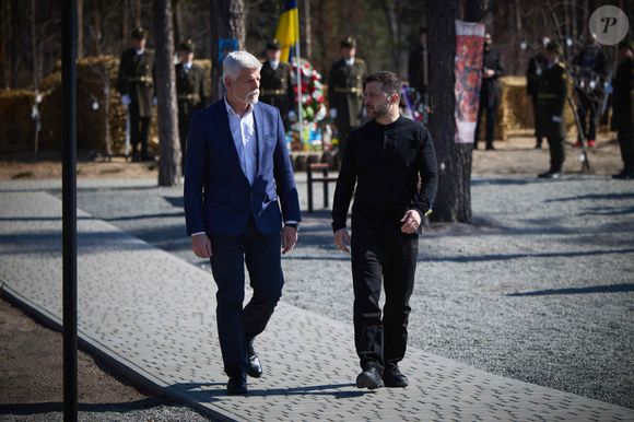 Le président ukrainien Volodymyr Zelensky et son homologue tchèque Petr Pavel visitent le mémorial de Moschun (Ukraine), le 21 mars 2025, à l'occasion de l'anniversaire de la libération de l'occupation russe en 2022.  Le village est devenu l'une des principales lignes défensives de Kiev, où se sont déroulées les batailles les plus acharnées lors de l'invasion russe en mars 2022.