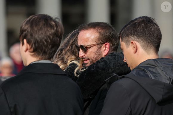 Devant une large assemblée venue honorer la mémoire de sa mère.

Michel Ferracci serre dans ses bras sa belle-fille, Milla Savarese, la fille de la défunte, sous le regard de ses fils Maël et Enzo Ferracci à la sortie des obsèques d'Emilie Dequenne au cimetière Père Lachaise à Paris, France, le 26 mars 2025. © Cyril Moreau/Bestimage