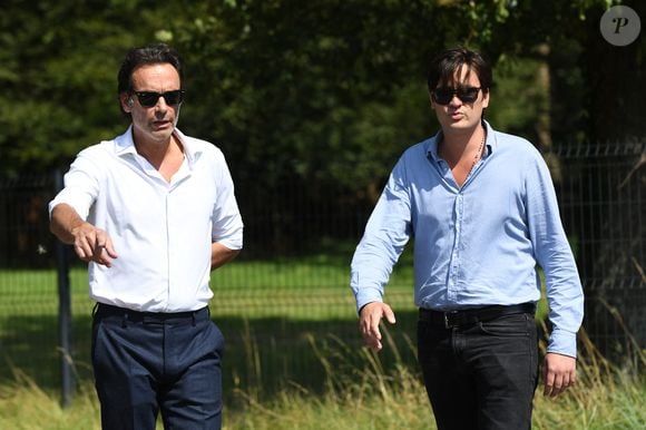 Anthony Delon et son demi-frère Alain-Fabien découvrent les hommages devant les grilles de la propriété de Douchy, quelques heures avant les obsèques de leur père, A.Delon, le 24 août 2024. © Agence / Bestimage