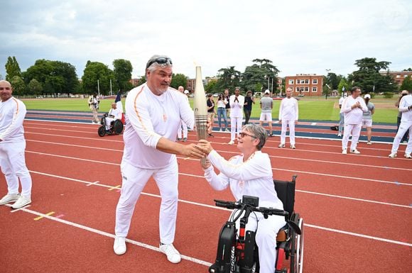 Les porteurs de la flamme olympique David Douillet et un invité à l'Institut national du sport, de l'expertise et de la performance (INSEP) pendant le relais de la flamme olympique à Paris le 15 juillet 2024. Photo par Paris 2024/Cedric Bufkens/SIPA PRESS/ABACAPRESS.COM