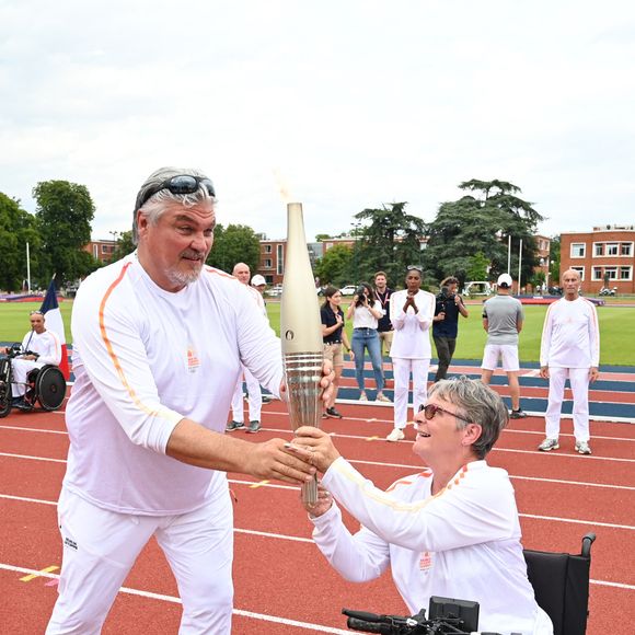 Les porteurs de la flamme olympique David Douillet et un invité à l'Institut national du sport, de l'expertise et de la performance (INSEP) pendant le relais de la flamme olympique à Paris le 15 juillet 2024. Photo par Paris 2024/Cedric Bufkens/SIPA PRESS/ABACAPRESS.COM