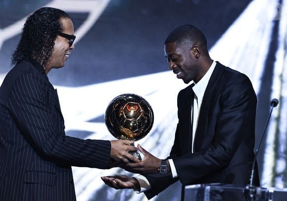 Le trophée de plusieurs kilos lui a été remis par l'ancien joueur de football brésilien Ronaldinho

Le joueur français du Paris Saint-Germain Ousmane Dembele (R) reçoit le Ballon d'Or des mains de l'ancien joueur de football brésilien Ronaldinho lors de la cérémonie de remise du Ballon d'Or France Football 2025 au Théâtre du Chatelet à Paris, France, le 22 septembre 2025. Photo de Gao Jing/Xinhua/ABACAPRESS.COM
