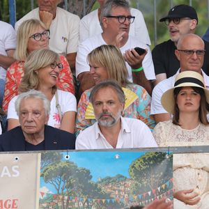 Semi-exclusif - Michel Sardou et sa femme Anne-Marie Périer, Romain Sardou et sa compagne Kym Thiriot enceinte - Michel Sardou rend hommage à son père en famille lors du premier trophée de pétanque "Fernand Sardou" à Bormes-les-Mimosas le 29 mai 2026. Le célèbre chanteur est venu en famille avec sa femme, son fils Romain avec son fils de deux ans et demi et de sa compagne enceinte de son deuxième enfant.
La première édition du Trophée Fernand Sardou est organisée du 29 au 31 mai au coeur du village de Bormes les Mimosas. Une initiative portée par Michel et son fils Romain, pour rendre hommage à leur illustre parent Fernand Sardou au travers d'un tournoi de pétanque.
En lien avec la municipalité et l'Amicale Bouliste Borméenne (ABB), un premier Trophée Fernand Sardou sera organisé avec deux grands temps forts : Le vendredi, dès 18h, un tournoi d'exhibition sera proposé et verra s'affronter 16 triplettes. Puis un concours fédéral à pétanque sera organisé le weekend et ouvert à tous les amateurs. 128 équipes seront réparties sur les sites les plus emblématiques du village, à savoir au boulodrome de la place Saint-François, mais aussi au parc Cigalou, sur le site du château et à l'ancien stade. © Franz Chavaroche/Bestimage