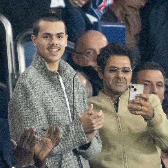 Jamel Debbouze et son fils Léon, Cindy Bruna et son futur mari Serge Ibaka - Célébrités dans les tribunes du match de Ligue des Champions entre le PSG contre le Bayern de Munich (1-2) au Parc des Princes à Paris le 4 novembre 2025. © Cyril Moreau/Bestimage