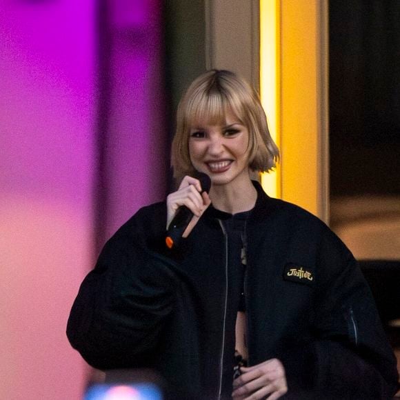 La chanteuse belge mélange habilement le style Art déco et les pièces iconiques.

La chanteuse Angèle dévoile son nouveau single "What You Want" en collaboration avec le duo électro français Justice avec une projection du clip sur la façade du Théâtre Royal de la Monnaie à Bruxelles le 25 février 2026.