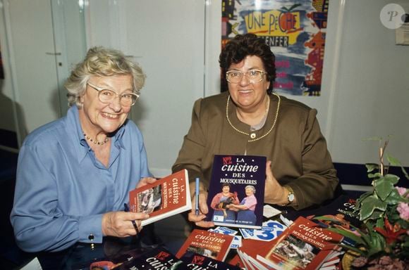 En France, à Paris,  Au Salon de l'Agriculture, stand du Conseil Regional d'Aquitaine de FRANCE3, Micheline Banzet-Lawton et Maïté, de son vrai nom Marie-Thérèse Ordonez réunies pour dédicacer leurs livres: La cuisine des Mousquetaires et la cuisine des Mousquetaires N°2 le 4 mars 1994.