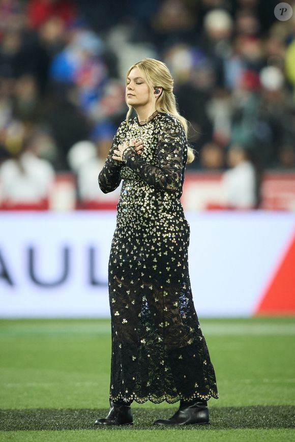 La chanteuse Louane (Louane Emera), représentante de la France au concours de l'Eurovision, interpréte pour la première fois son titre Maman, en hommage à sa mère décédée lorsqu'elle avait 17 ans, devant les 80 000 spectateurs, suspendue sur une plateforme, plusieurs mètres au-dessus de la pelouse et des musiciens, du Stade de France à la mi-temps du match du Tournoi des Six Nations opposant la France à l'Écosse, à Saint-Denis, Seine Saint-Denis, France, le 15 mars 2025. © Cyril Moreau/Bestimage