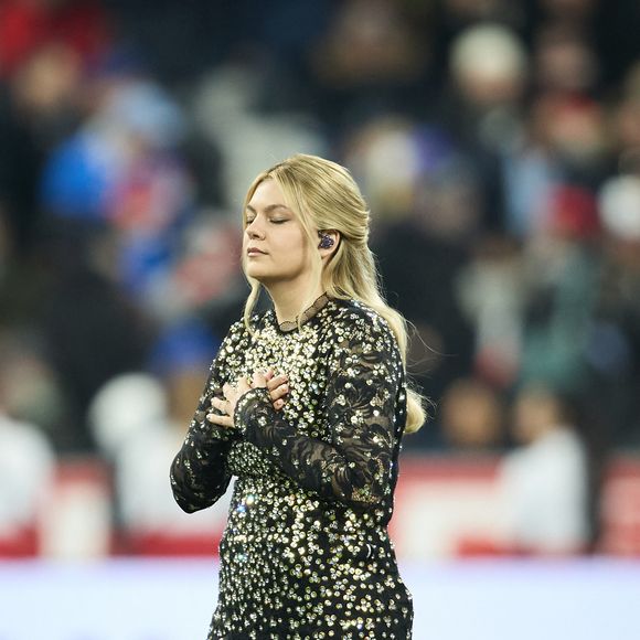 La chanteuse Louane (Louane Emera), représentante de la France au concours de l'Eurovision, interpréte pour la première fois son titre Maman, en hommage à sa mère décédée lorsqu'elle avait 17 ans, devant les 80 000 spectateurs, suspendue sur une plateforme, plusieurs mètres au-dessus de la pelouse et des musiciens, du Stade de France à la mi-temps du match du Tournoi des Six Nations opposant la France à l'Écosse, à Saint-Denis, Seine Saint-Denis, France, le 15 mars 2025. © Cyril Moreau/Bestimage