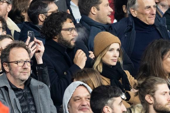 Maxim Nucci (Yodelice) et sa compagne Isabelle Ithurburu dans les tribunes lors du match de rugby du Tournoi des 6 Nations opposant la France à l'Angleterre au stade de France, à Saint-Denis, Seine Saint-Denis, France, le 19 mars 2022. © Cyril Moreau/Bestimage