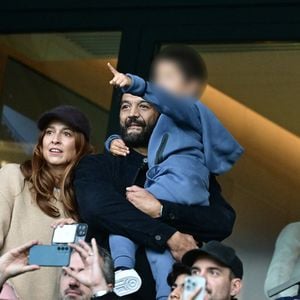 Ramzy Bedia avec sa compagne Marion et son fils en tribunes lors du match de football Ligue 1 Uber Eats opposant le Paris Saint-Germain (PSG) à l'OGC Nice (1-0) au Parc des Princes à Paris, France, le 1er novembre 2025. © Christian Liewig/Bestimage