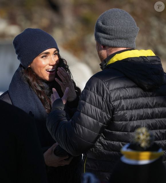 15 février 2024, Whistler, Bc, CANADA : Meghan Markle, à gauche, la duchesse de Sussex, réagit en écoutant le prince Harry, le duc de Sussex, après qu'il ait glissé sur la piste sur une luge de skeleton lors d'un camp d'entraînement des Invictus Games, à Whistler, en Colombie-Britannique, le jeudi 15 février 2024. (Crédit photo : Zuma Press / Bestimage)