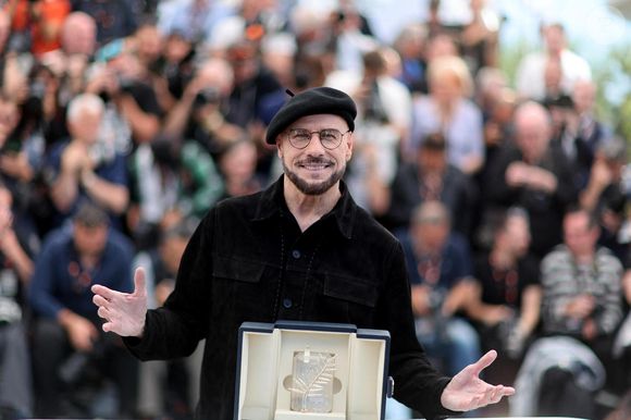 John Travolta pose avec sa Palme d'or d'honneur au photocall du film "Propeller One-Way Night Coach" lors du 79ème Festival International du Film de Cannes, France, le 16 mai 2026. © Jacovides-Moreau/bestimage