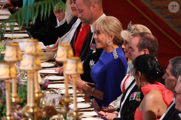 Une vidéo diffusée sur TikTok a cependant détourné l’attention : on y voit le prince William se rasseoir avant tout le monde au moment du toast, rompant brièvement avec le protocole royal.

Le prince William, prince de Galles (2e à gauche), l’épouse du président français Brigitte Macron (3e à gauche) et la reine Camilla du Royaume-Uni (5e à droite) assistent à un banquet d’État au château de Windsor, à l’ouest de Londres, le 8 juillet 2025, lors du premier jour de la visite d’État de trois jours du président français au Royaume-Uni.
— Le président Emmanuel Macron a entamé mardi une visite d’État de trois jours en Grande-Bretagne, au cours de laquelle il a pris la parole devant le Parlement et tenté de raviver une relation dite chaleureuse avec le roi Charles III.
© Ludovic Marin / Pool / Bestimage