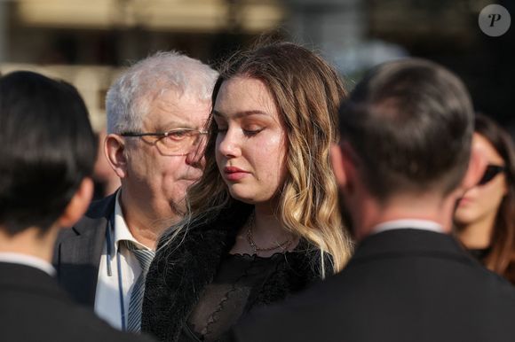 Milla Savarese, la fille de la défunte et son grand-père Daniel Dequenne à la sortie des obsèques d'Emilie Dequenne au cimetière Père Lachaise à Paris, France, le 26 mars 2025. © Cyril Moreau/Bestimage