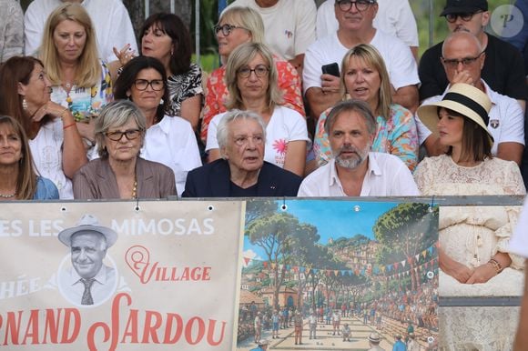 Semi-exclusif - Michel Sardou et sa femme Anne-Marie Périer, Romain Sardou et sa compagne Kym Thiriot enceinte - Michel Sardou rend hommage à son père en famille lors du premier trophée de pétanque "Fernand Sardou" à Bormes-les-Mimosas le 29 mai 2026. Le célèbre chanteur est venu en famille avec sa femme, son fils Romain avec son fils de deux ans et demi et de sa compagne enceinte de son deuxième enfant.
La première édition du Trophée Fernand Sardou est organisée du 29 au 31 mai au coeur du village de Bormes les Mimosas. Une initiative portée par Michel et son fils Romain, pour rendre hommage à leur illustre parent Fernand Sardou au travers d'un tournoi de pétanque.
En lien avec la municipalité et l'Amicale Bouliste Borméenne (ABB), un premier Trophée Fernand Sardou sera organisé avec deux grands temps forts : Le vendredi, dès 18h, un tournoi d'exhibition sera proposé et verra s'affronter 16 triplettes. Puis un concours fédéral à pétanque sera organisé le weekend et ouvert à tous les amateurs. 128 équipes seront réparties sur les sites les plus emblématiques du village, à savoir au boulodrome de la place Saint-François, mais aussi au parc Cigalou, sur le site du château et à l'ancien stade. © Franz Chavaroche/Bestimage
