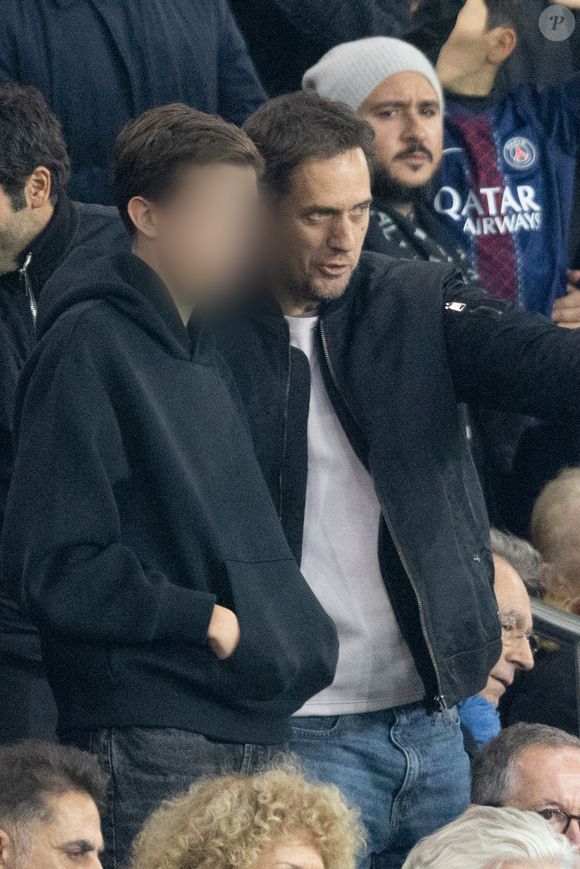 Grand Corps Malade et son fils - Célébrités dans les tribunes du match de Ligue des Champions entre le PSG contre le Bayern de Munich (1-2) au Parc des Princes à Paris le 4 novembre 2025. © Cyril Moreau/Bestimage