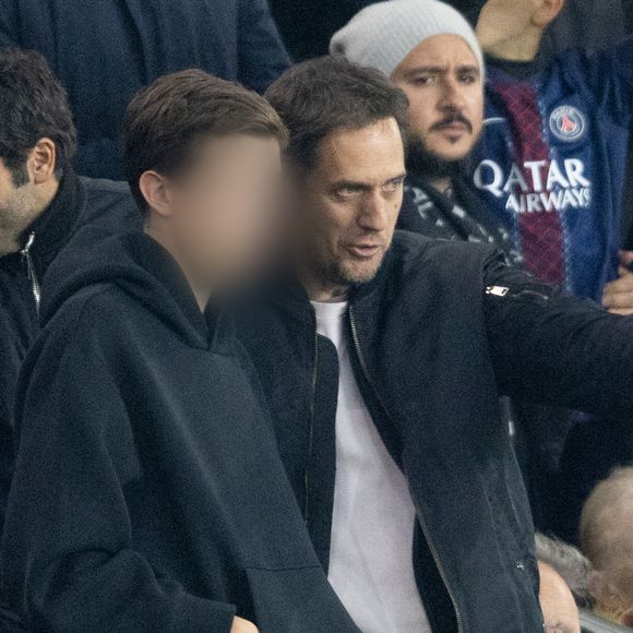 Grand Corps Malade et son fils - Célébrités dans les tribunes du match de Ligue des Champions entre le PSG contre le Bayern de Munich (1-2) au Parc des Princes à Paris le 4 novembre 2025. © Cyril Moreau/Bestimage