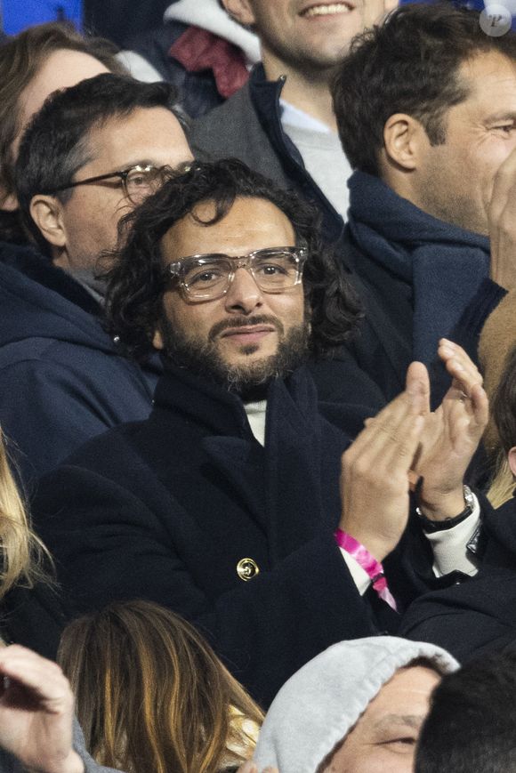 Maxim Nucci (Yodelice) et sa compagne Isabelle Ithurburu dans les tribunes lors du match de rugby du Tournoi des 6 Nations opposant la France à l'Angleterre au stade de France, à Saint-Denis, Seine Saint-Denis, France, le 19 mars 2022. © Cyril Moreau/Bestimage