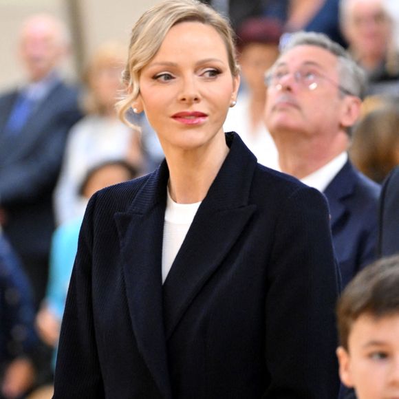 Son look, minimaliste et chic, était complété par des escarpins Manolo Blahnik et un chignon bas.

La princesse Charlene de Monaco a rendu hommage à la présidente et fondatrice de Special Olympics Monaco en baptisant un gymnase scolaire du Stade Louis II de son nom, Mireille Calmes, en présence de son fils Jean François Calmes et son petit fils Anton, le 18 octobre 2025. © Bruno Bebert/Bestimage