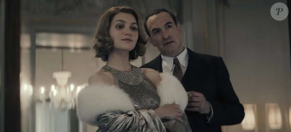 Dans ce drame historique, il incarne le journaliste Jean Luchaire, figure controversée de la collaboration pendant la Seconde Guerre mondiale.

Jean Dujardin et Nastya Golubeva dans "Les Rayons et les Ombres" de Xavier Giannoli.

Copyright 2026 WAITING FOR CINEMA – CURIOSA FILMS – GAUMONT – FRANCE 3 CINÉMA