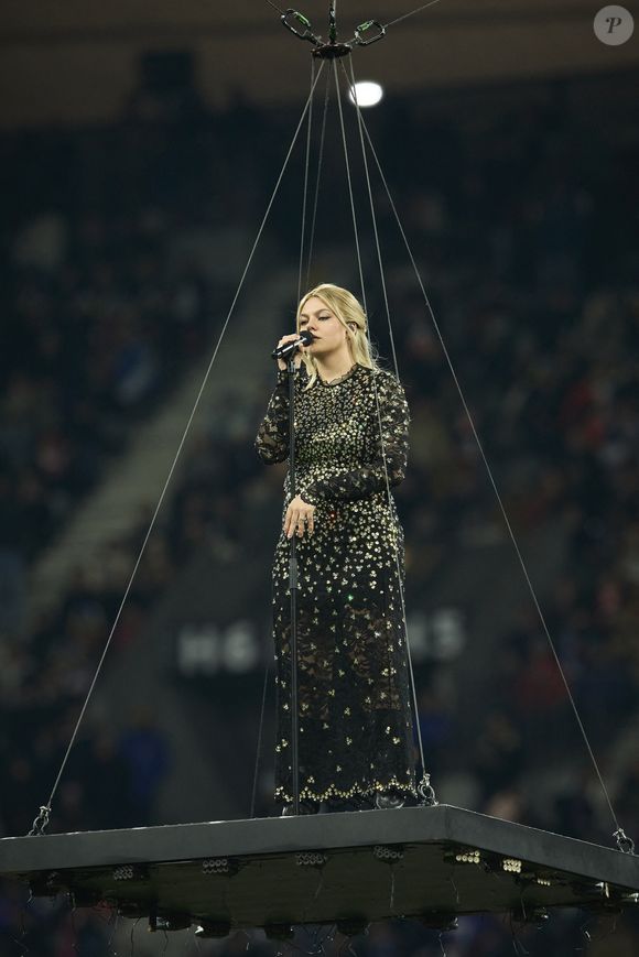 La chanteuse Louane (Louane Emera), représentante de la France au concours de l'Eurovision, interpréte pour la première fois son titre Maman, en hommage à sa mère décédée lorsqu'elle avait 17 ans, devant les 80 000 spectateurs, suspendue sur une plateforme, plusieurs mètres au-dessus de la pelouse et des musiciens, du Stade de France à la mi-temps du match du Tournoi des Six Nations opposant la France à l'Écosse, à Saint-Denis, Seine Saint-Denis, France, le 15 mars 2025. © Cyril Moreau/Bestimage