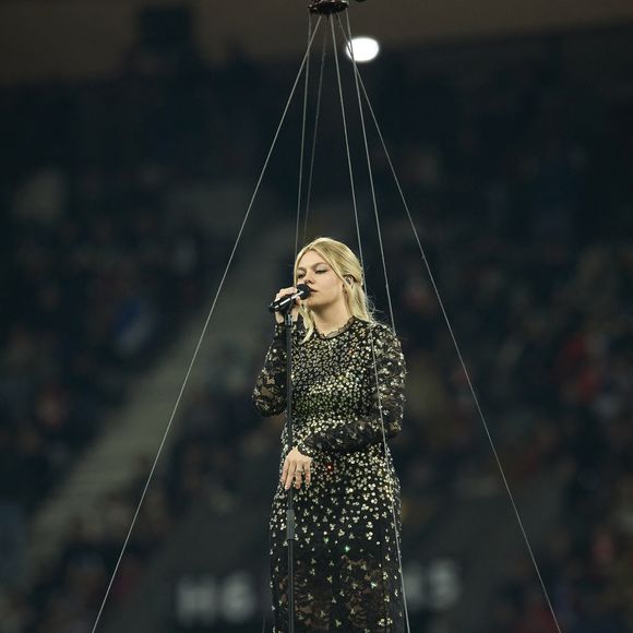 La chanteuse Louane (Louane Emera), représentante de la France au concours de l'Eurovision, interpréte pour la première fois son titre Maman, en hommage à sa mère décédée lorsqu'elle avait 17 ans, devant les 80 000 spectateurs, suspendue sur une plateforme, plusieurs mètres au-dessus de la pelouse et des musiciens, du Stade de France à la mi-temps du match du Tournoi des Six Nations opposant la France à l'Écosse, à Saint-Denis, Seine Saint-Denis, France, le 15 mars 2025. © Cyril Moreau/Bestimage