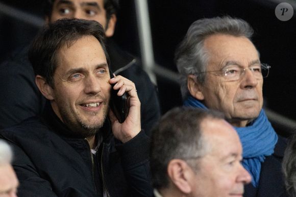 Grand Corps Malade et Michel Denisot - Célébrités dans les tribunes du match de Ligue des Champions entre le PSG contre le Bayern de Munich (1-2) au Parc des Princes à Paris le 4 novembre 2025. © Cyril Moreau/Bestimage