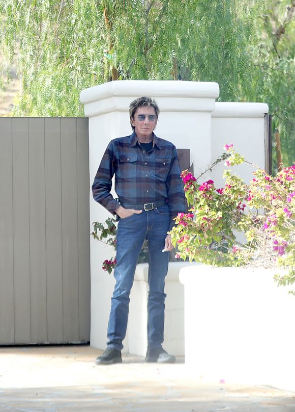 Exclusif - Barry Manilow vapote devant sa villa de Palm Springs, le 3 décembre 2024, malgré un cancer de la gorge dont il souffrait en 2018. Coleman-Rayner / Bestimage