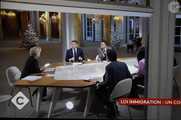 Le président français Emmanuel Macron avec Anne-Elisabeth Lemoine, Mohamed Bouhafsi, Patrick Cohen sur un écran de télévision à Paris lors d'une interview en direct diffusée dans l'émission '' C a vous '' de France 5, le 20 décembre 2023. Photo by Eliot Blondet/ABACAPRESS.COM