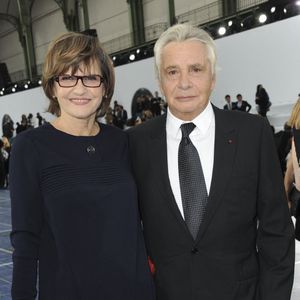 Michel Sardou et son épouse Anne-Marie Perier assistent au défilé de la collection prêt-à-porter printemps-été 2013 de Chanel qui s'est tenu au Grand Palais à Paris, France, le 2 octobre 2012. Photo by Thierry Orban/ABACAPRESS.COM