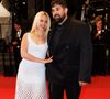 La main délicatement posée sur le bras de son acolyte, Kim Higelin a partagé de francs sourires avec Artus, comme elle le faisait déjà quelques jours plus tôt lors d'une autre avant-première à Cannes.

Artus et sa compagne Kim Higelin - Montée des marches du film "Jim Queen" lors du 79ème Festival International du Film de Cannes le 18 mai 2026.

© Moreau / Jacovides / Bestimage
