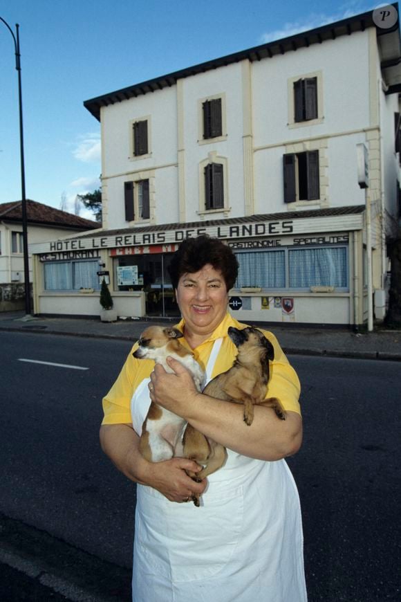 Archives - Maïté (Marie-Thérèse Ordonez) pose à son restaurant  "Le relais des Landes" à Rion-des-Landes en 1992. Elle pose avec ses deux chiens, Sissi et Alto, des Pinscher nain

© Alain Canu via Bestimage