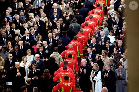 Brigitte Macron, Donald Trump, Emmanuel Macron, Michel Barnier, sa femme Isabelle Altmayer, Nicolas Sarkozy, sa femme Carla Bruni et l'assistance rendent hommage aux pompiers de Paris - Cérémonie de réouverture de la cathédrale Notre-Dame de Paris, le 7 décembre 2024. Joyau de l’art gothique, lieu de culte et de culture, symbole universel de la France et de son histoire, la cathédrale de Notre-Dame de Paris rouvre ses portes les 7 et 8 décembre, cinq ans après le terrible incendie qui l’avait ravagée le 15 avril 2019. 
© Dominique Jacovides / Bestimage